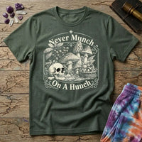 Never Munch on a Hunch engraved skull beside a foraging basket of wild mushrooms, on a Military Green unisex t-shirt