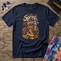Spore Me the Details lettering above a mushroom character taking notes over spore prints, on a Navy unisex t-shirt