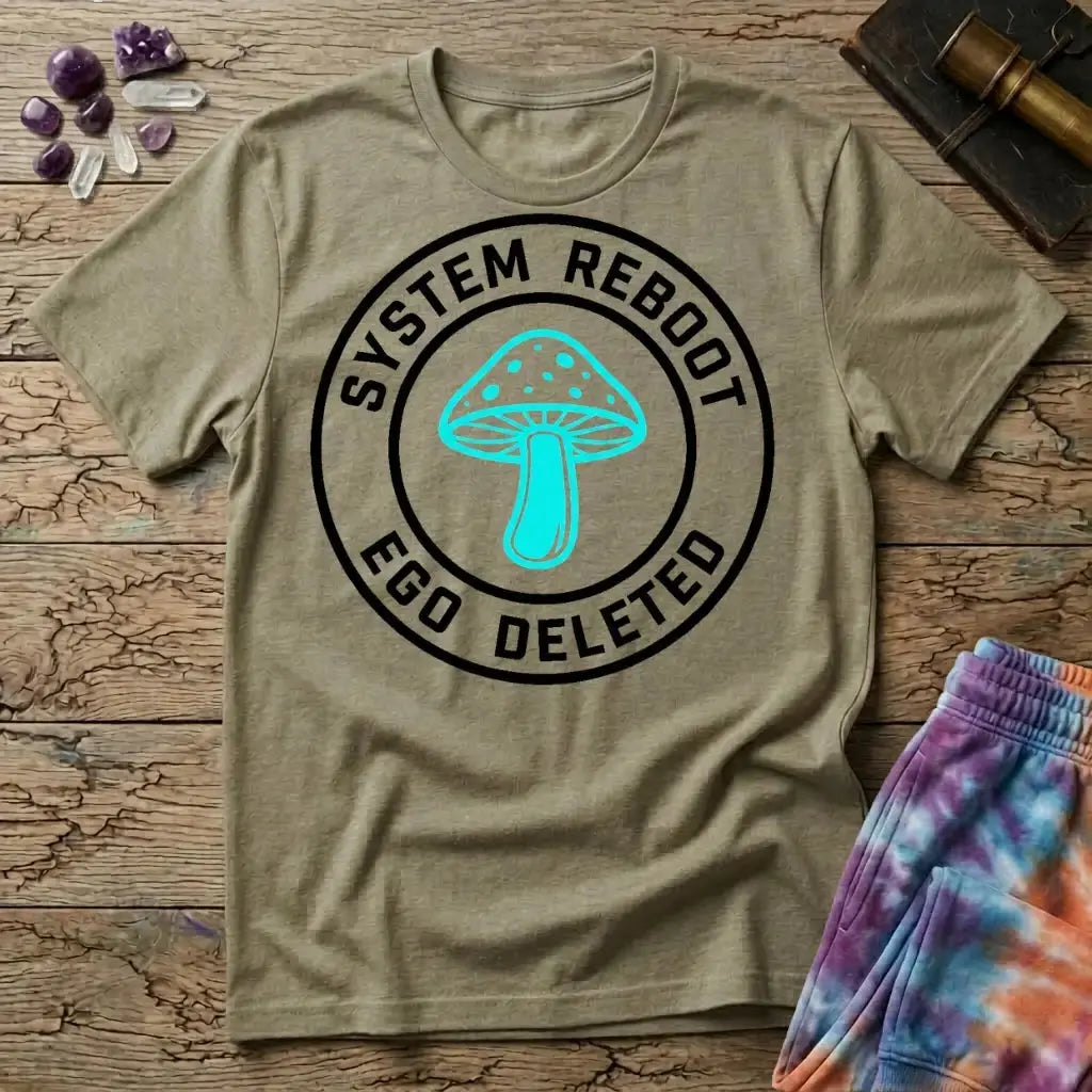 System Reboot Ego Deleted circular badge with a turquoise mushroom at its center, on a Sand unisex t-shirt