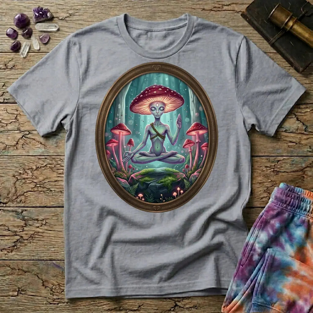 A mushroom-capped alien meditating on a mossy rock in an oval forest frame, on a Sport Grey unisex t-shirt