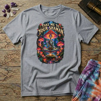 Take Me to Your Shaman lettering above a neon amanita-crowned figure meditating in a glowing forest, on a Sport Grey unisex t-shirt