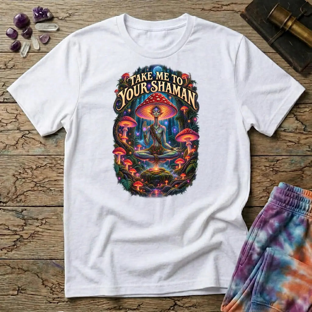 Take Me to Your Shaman lettering above a neon amanita-crowned figure meditating in a glowing forest, on a White unisex t-shirt