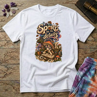 Spore Me the Details lettering above a mushroom character taking notes over spore prints, on a White unisex t-shirt