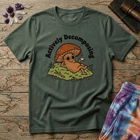 Mushroom in sunglasses kicked back on moss with a coffee, under Actively Decomposing lettering, on a unisex t-shirt