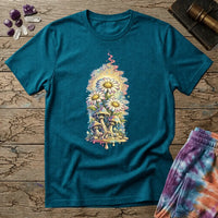 Daisies blooming from dripping mushrooms in front of a glowing sun mandala and rainbow trails, on a unisex t-shirt