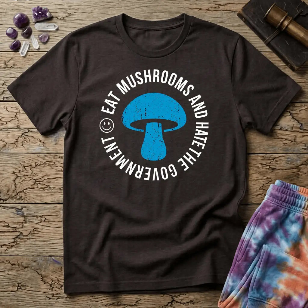 Distressed blue mushroom badge ringed by circle text and a small smiley face, on a unisex t-shirt