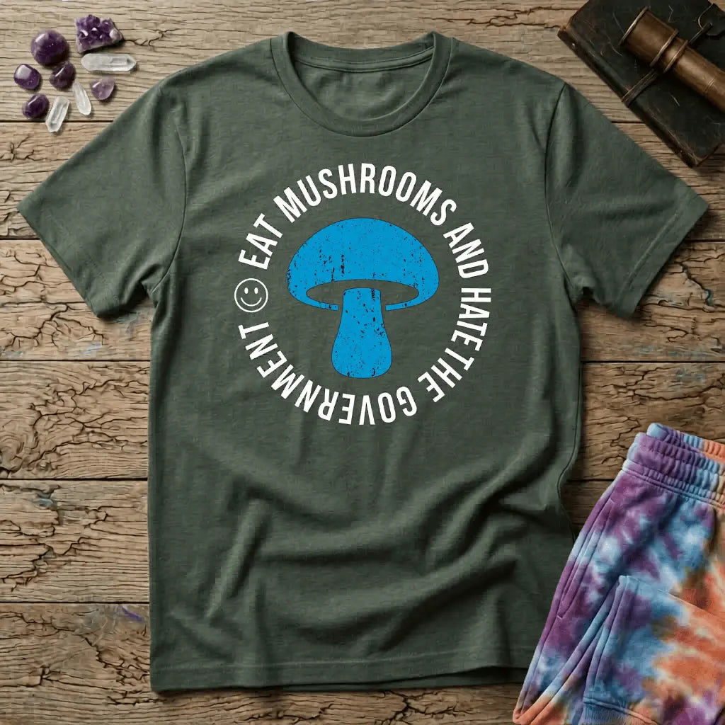 Distressed blue mushroom badge ringed by circle text and a small smiley face, on a unisex t-shirt