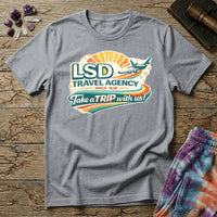 Retro airline-style badge with a plane soaring past a golden sunburst and rainbow streaks, reading LSD Travel Agency, on a unisex t-shirt