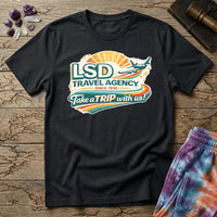 Retro airline-style badge with a plane soaring past a golden sunburst and rainbow streaks, reading LSD Travel Agency, on a unisex t-shirt